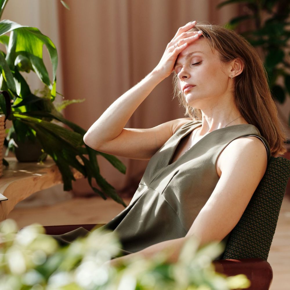 Vrouw die tijdens beeldschermwerk hoofdpijn ervaart
